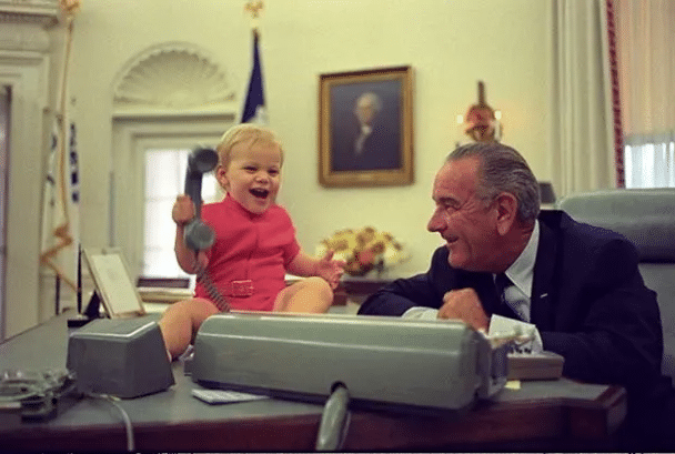 Prezydent Lyndon B. Johnson obserwuje, jak jego wnuk bawi się telefonem — Yoichi Okamoto, 1968 r.